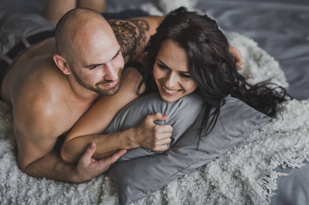 A young couple laughing in bed 150. - 写真・画像