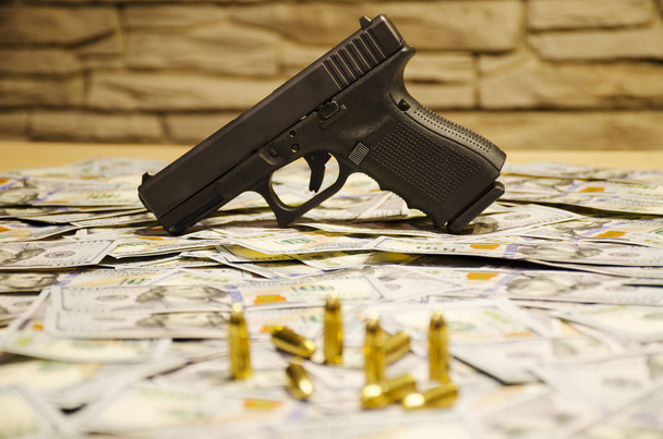 Het wapen met wazig kogels vastgesteld op wazig dollar - Foto, afbeelding