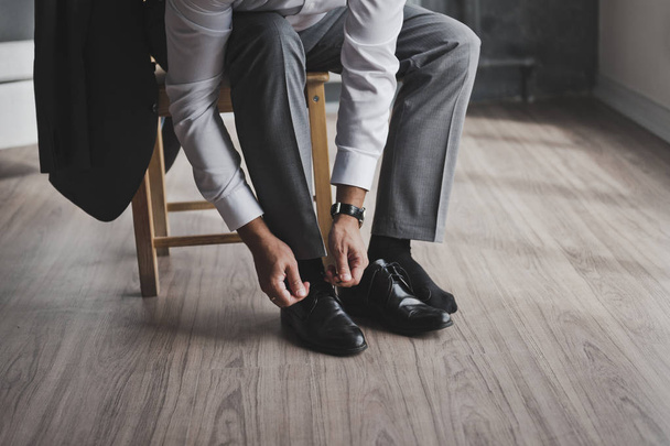 A man in a business suit ties the laces 336. - Photo, Image