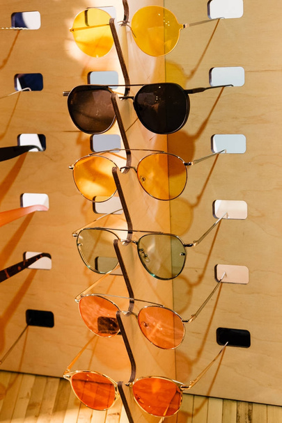 große Auswahl an Sonnenbrillen und Gläsern auf einem Ständer - Foto, Bild