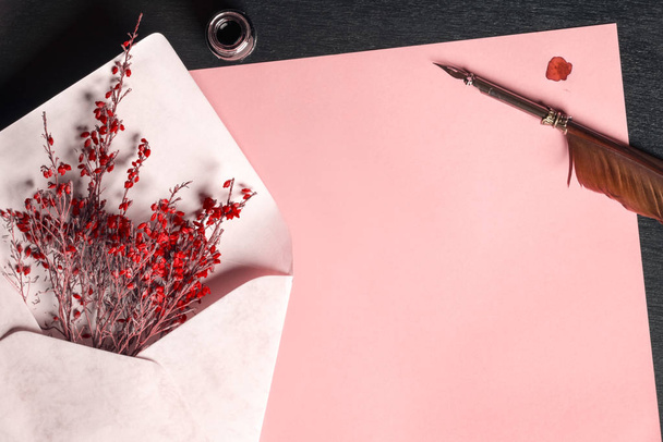 Конверт с цветами на бумаге и перьевой ручкой
 - Фото, изображение