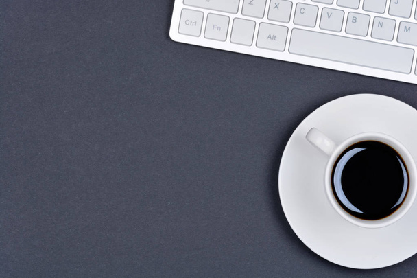 Tazza di caffè con tastiera del computer su sfondo nero
 - Foto, immagini
