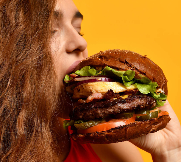 Tasty unhealthy burger sandwich in woman hands hungry mouth getting ready to eat - Photo, image