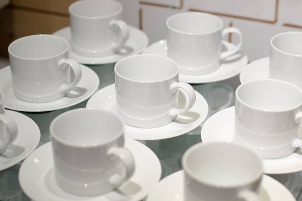 Білі керамічні чашки встановлені на дисплеї
 - Фото, зображення