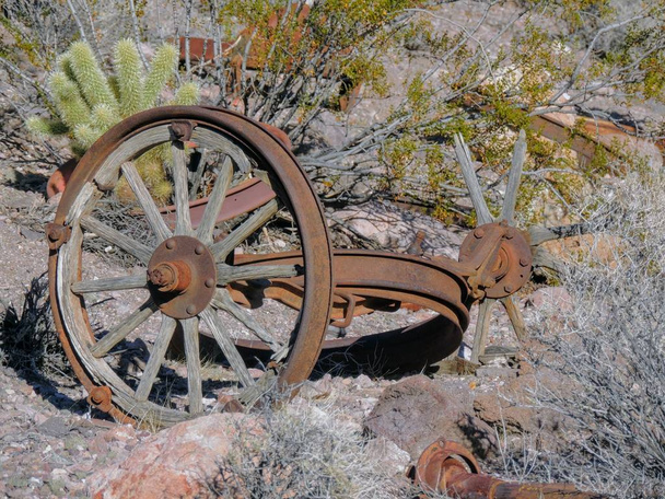 Oude banden met metalen Wagon wheel pieken in de woestijn in Arizona in een verlaten spookstad met mijnbouw. - Foto, afbeelding