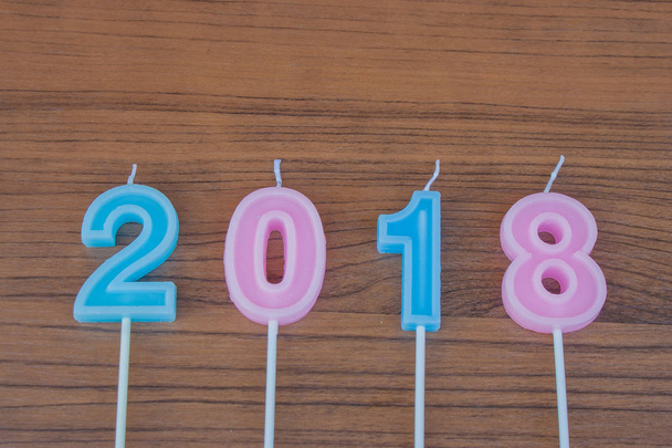 Yeni yıl kavramı: yeni yıl 2018 ifadeler yapılmış renkli mumlar ahşap masanın üstüne koy. (Seçici odak) - Fotoğraf, Görsel