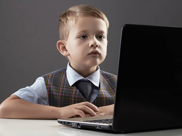 Nuori poika tietokoneen kanssa. lapsi katselee muistikirjaan
 - Valokuva, kuva