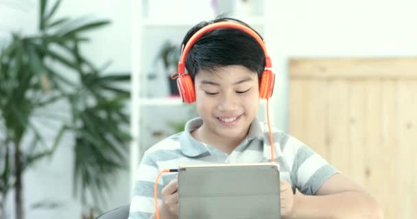 primer plano de asiático preadolescentes jugando tableta ordenador con sonrisa cara en casa
. - Imágenes, Vídeo