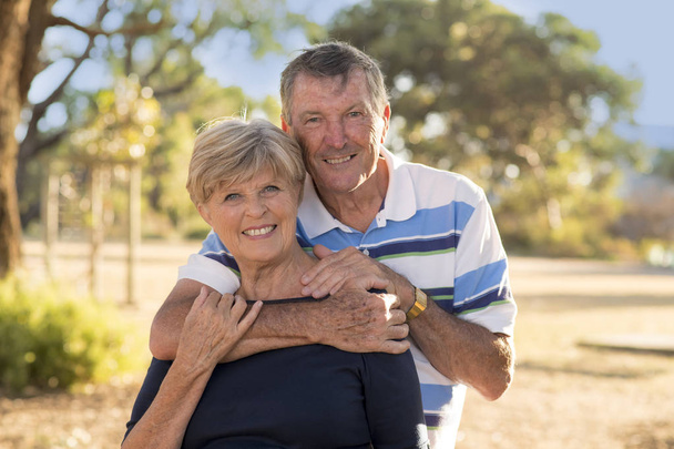 Porträt amerikanischer Senioren schönes und glückliches reifes Paar um die 70 Jahre, das Liebe und Zuneigung zeigt und zusammen im Park lächelt - Foto, Bild