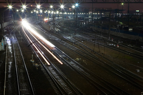 The train rushes on the rails at night. - Fotografie, Obrázek