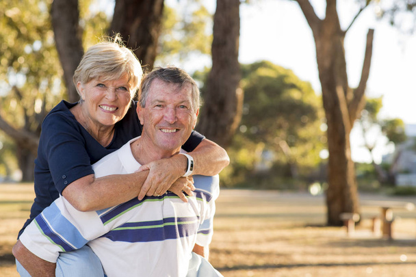 πορτρέτο της αμερικανικής ανώτερος όμορφο και ευτυχισμένο ζευγάρι περίπου 70 ετών δείχνει αγάπη και στοργή χαμογελώντας μαζί στο πάρκο - Φωτογραφία, εικόνα