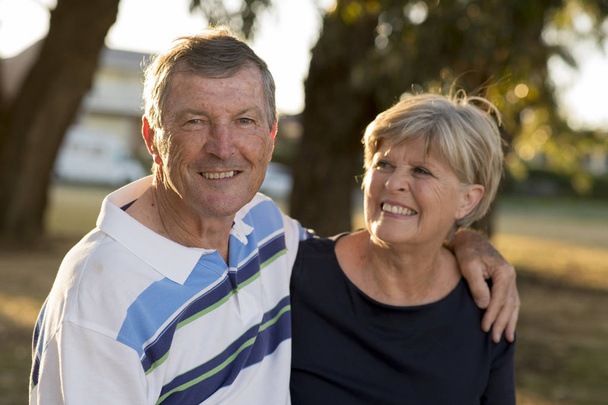 πορτρέτο της αμερικανικής ανώτερος όμορφο και ευτυχισμένο ζευγάρι περίπου 70 ετών δείχνει αγάπη και στοργή χαμογελώντας μαζί στο πάρκο - Φωτογραφία, εικόνα