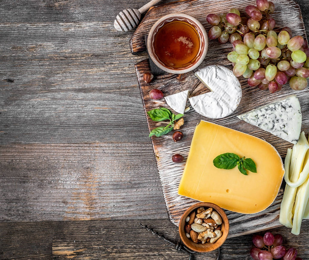 Cheese plate served with wine, nuts and honey - 写真・画像