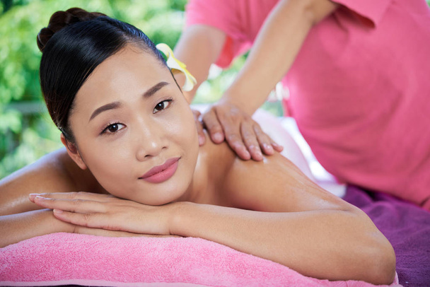 Jovem mulher asiática tendo massagem nas costas com óleos
 - Foto, Imagem