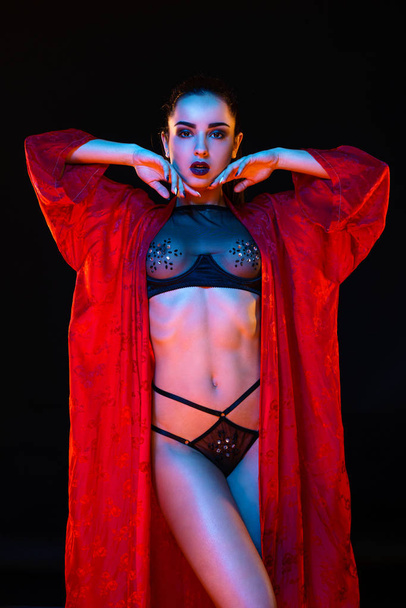 Sensual yound woman posing against dark studio background  - Foto, imagen