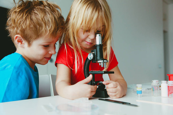 Kids learn to use microscope, science class, home learning concept - Photo, Image