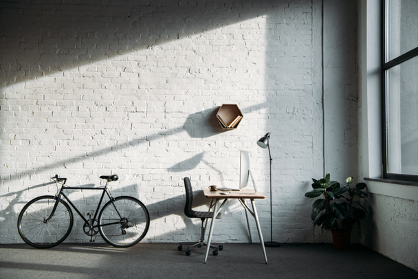 bicycle and working table with computer in office - Photo, Image
