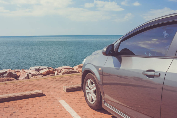 Car parked on parking lot  at the coast with beautiful seascape background in vintage style. - Photo, Image