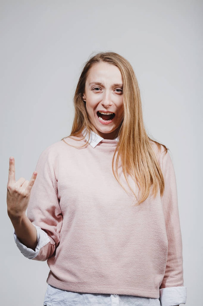Fiatal csípő nő mutatja a rock and roll odaad gesztus - Fotó, kép