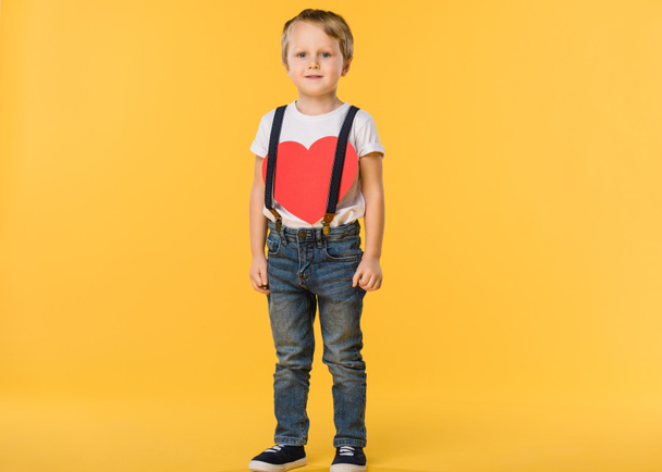 adorable little boy with red paper heart isolated on yellow, st valentines day concept - Photo, Image
