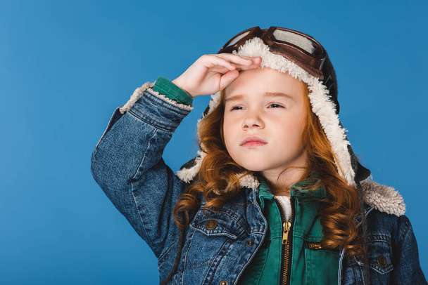 portrait of adorable preteen kid in pilot costume isolated on blue - 写真・画像
