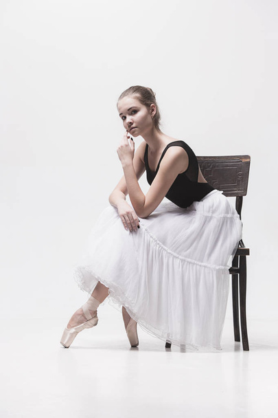The teen ballerina in white pack sitting on chair - Фото, изображение