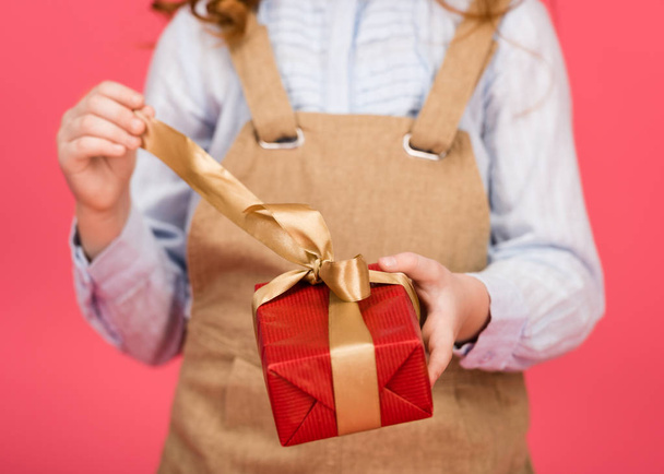 cropped shot of kid with wrapped present in hands isolated on pink - Photo, Image