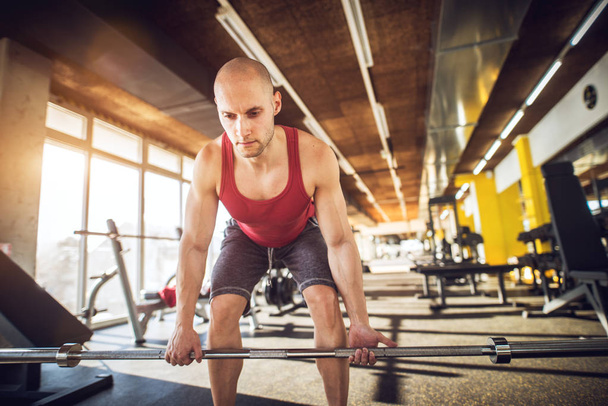 bodybuilder concentrato che fa squat con il bilanciere in palestra
. - Foto, immagini