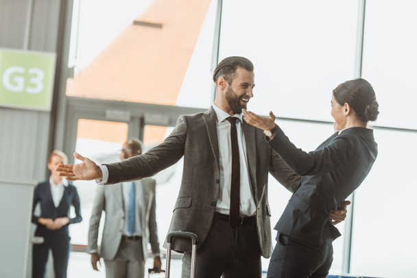 счастливый бизнесмен обнимает коллегу в аэропорту
 - Фото, изображение