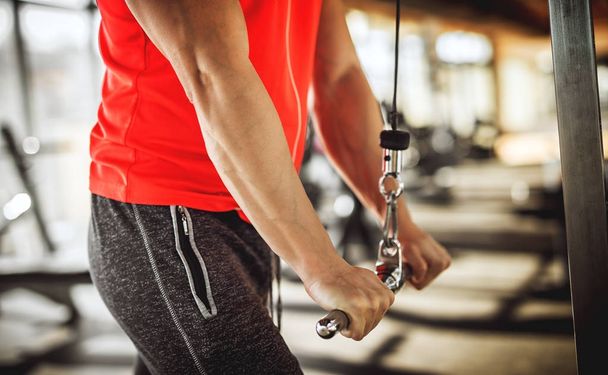  vahva lihaksikas mies tekee triceps liikunta koneella kuntosalilla
 - Valokuva, kuva