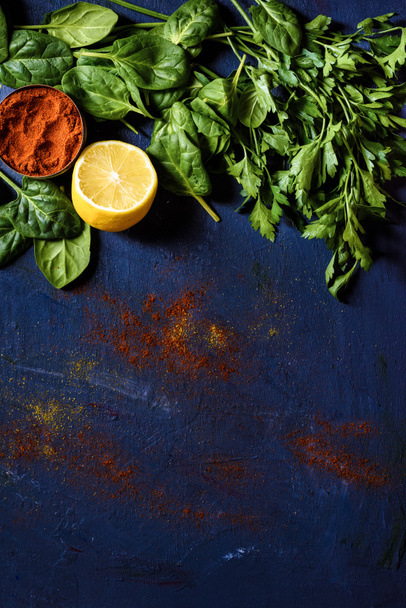 top view of lemon, red pepper, parsley and basil on blue - Photo, Image