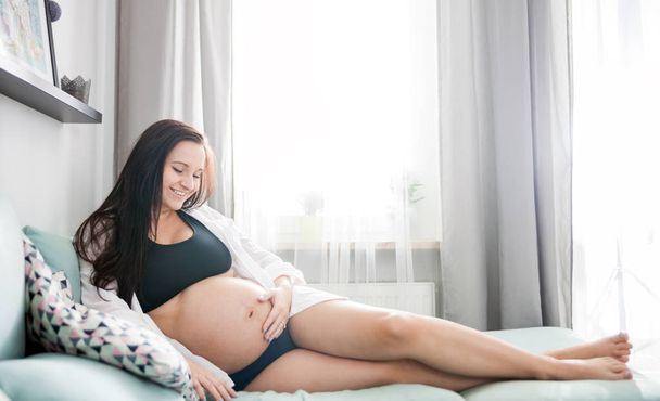 Gülümseyen hamile kadın kanepe evde istirahat yalan rahat - Fotoğraf, Görsel