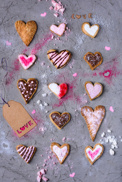 top view of sweet traditional heart shaped cookies with love tag on grey cracked surface  - Valokuva, kuva