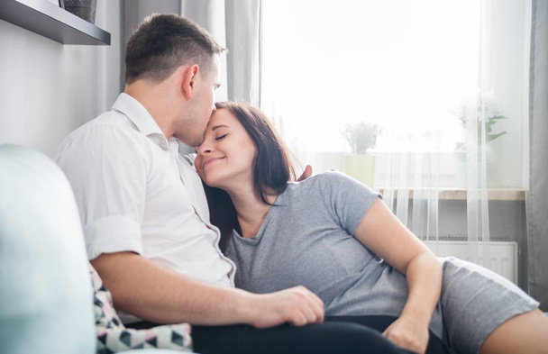 Cheerful pregnant couple relaxing at home and enjoying pregnancy time - Foto, Imagem