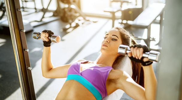 beautiful fitness young woman exercising with dumbbells in gym - Fotografie, Obrázek