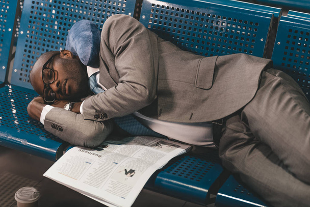усталый бизнесмен спит на местах в ожидании рейса в вестибюле аэропорта
 - Фото, изображение