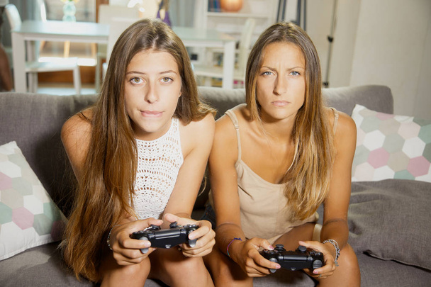 Lindos adolescentes jugando videojuego sosteniendo joystick
 - Foto, imagen