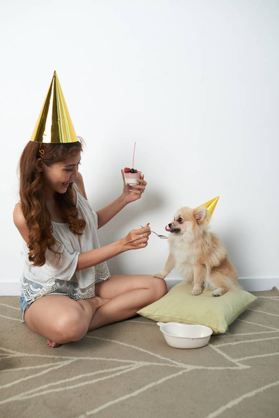 Cheerful Vietnamese girl celebrating birthday of her dog - Foto, afbeelding