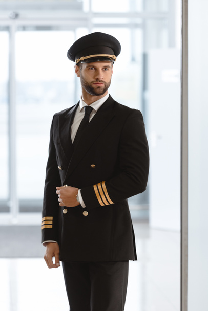 guapo joven piloto de uniforme en el aeropuerto
 - Foto, Imagen