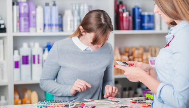Customer woman choosing cosmetics with assistant in beauty store - Foto, afbeelding