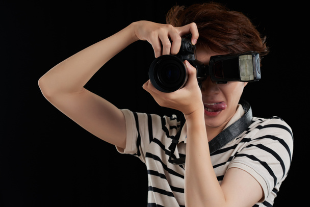 Nuori vietnamilainen miesvalokuvaaja nauttii työstään
 - Valokuva, kuva
