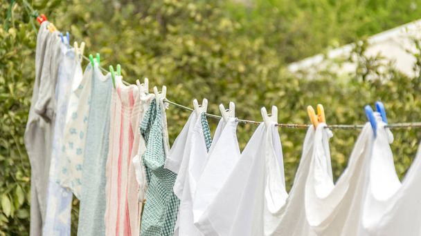 Çamaşırhane satırıyla beyaz giysiler ve yeşil doğa arka plan. - Fotoğraf, Görsel