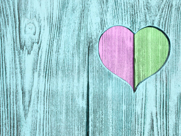 Green and pink heart carved in a wooden board. Background. Postcard, valentine. - Photo, image