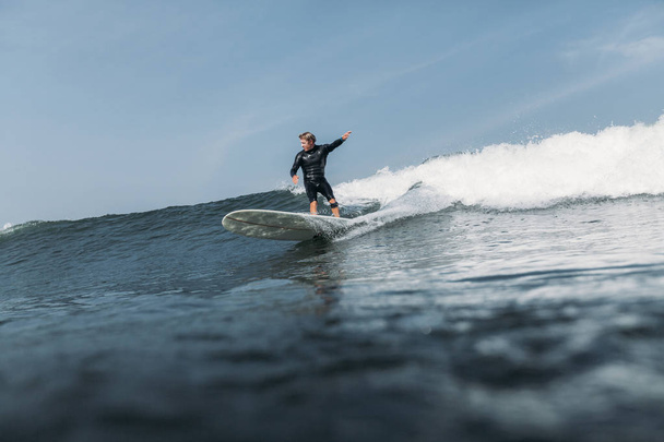 hombre que se divierte y surf ola a bordo en el océano
  - Foto, Imagen