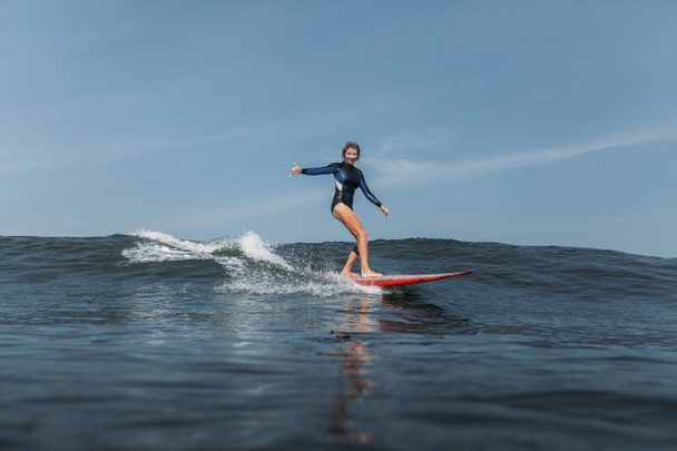 woman having fun and riding wave on surf board in ocean - Photo, Image