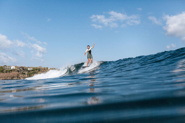 girl riding wave on surf board in ocean - 写真・画像