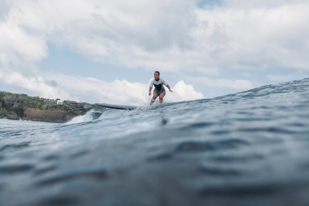 mujer montando olas en tabla de surf en el océano
 - Foto, imagen