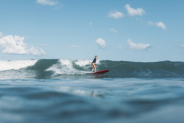 sportswoman riding wave on surf board in ocean - Photo, Image