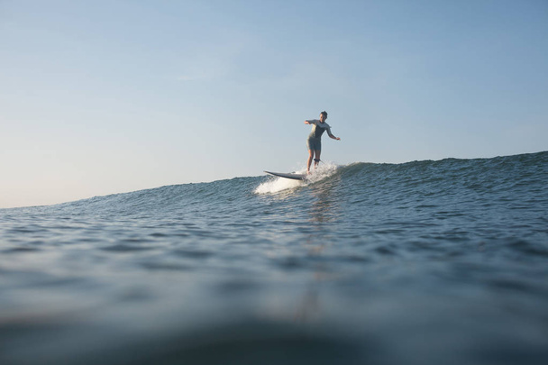 sportswoman surfing the wave on surf board in ocean - Photo, Image