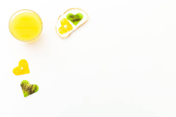 Chutný sendvič s ovocem a čerstvou citrusovou šťávu na bílém pozadí. Plochá ležel, horní pohled - Fotografie, Obrázek